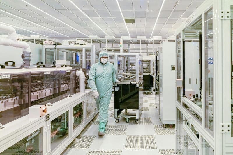 Photograph of a worker in a protective suit in a pharmaceutical clean room.