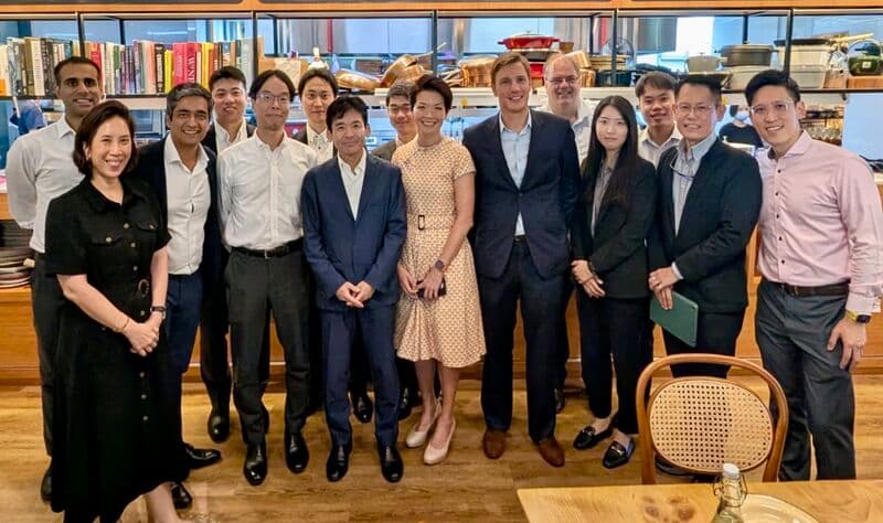 Group photograph of about fifteen people standing together indoors, as shared in the original post.